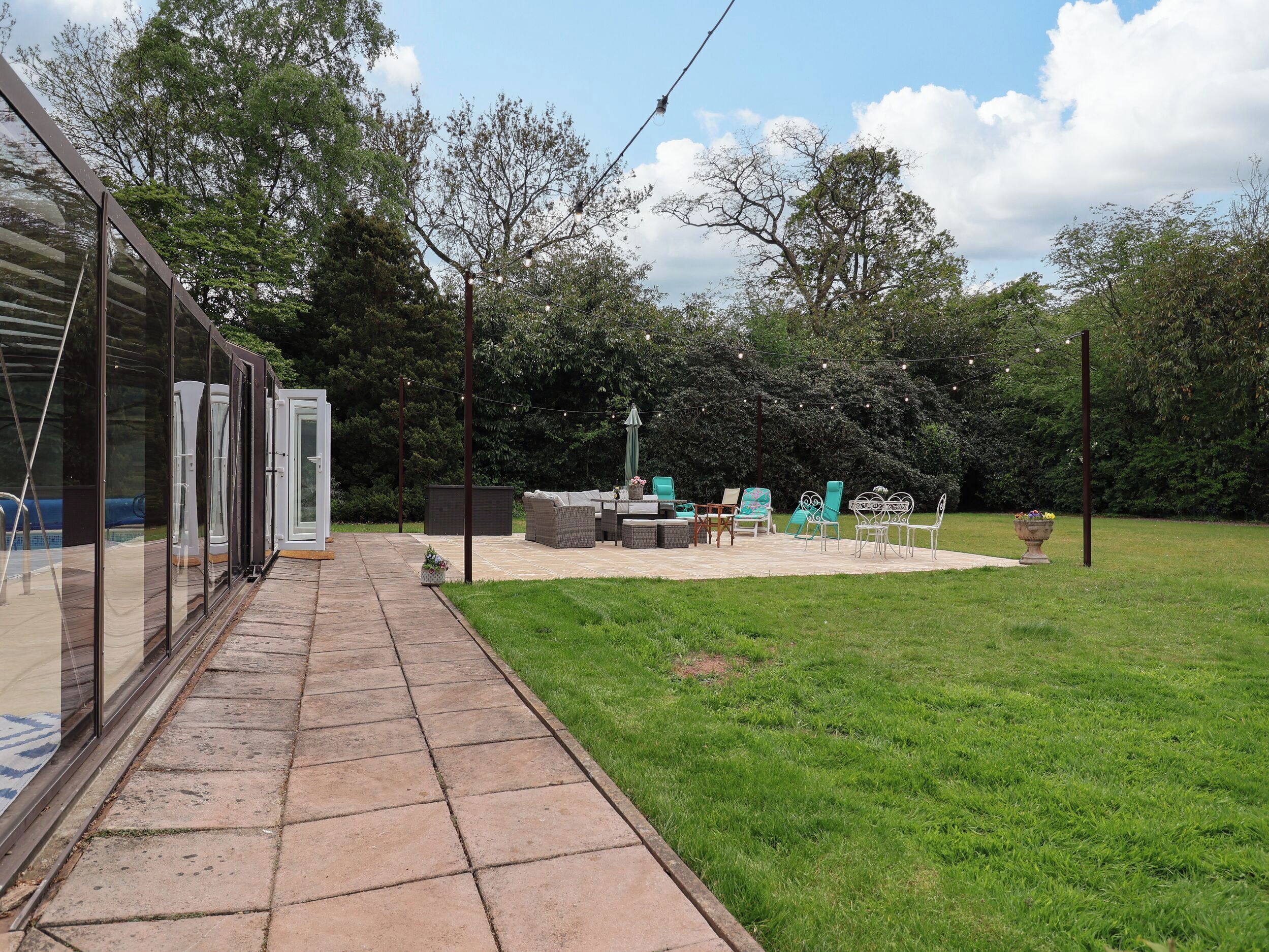 Eine Terrasse mit Gartenmöbeln, einem kleinen Tisch und einer Sitzecke.