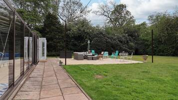 Eine Terrasse mit Gartenmöbeln, einem kleinen Tisch und einer Sitzecke.
