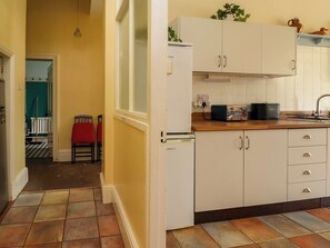 A kitchen with white cabinets, a toaster, and a kettle on the counter.