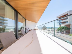 A modern balcony with a wooden ceiling, a white table, and two chairs. - OL RETREAT 4 2.AE in Olhão (Olhão)