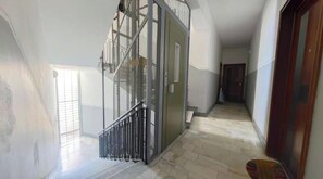 Un corridoio con una scala, una porta e una finestra.