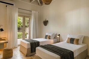 A room with two beds, a desk, and a window with curtains. - Villa Ainos of Lithos Villas (Vlachata)