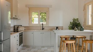 Eine Küche mit Kochinsel, doppelter Spüle und Holzstühlen.