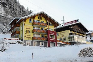 A multi-story building with a yellow facade, balconies, and signage for a hotel and restaurant. - Hotel-Gasthof Posauner (Sankt Veit im Pongau)