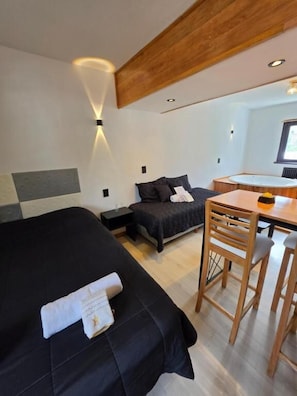 A modern hotel room with a bed, a desk, and a chair. - Hotel Surprise  (San Carlos de Bariloche)
