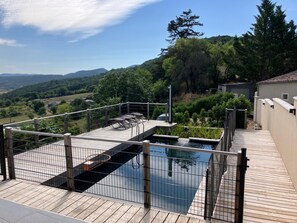 A rooftop pool with a wooden deck, metal railings, and a view of the surrounding landscape. - Maison Lara with natural swimming pool in the heart of the Cathar countryside 7 people (Saint-Ferriol)