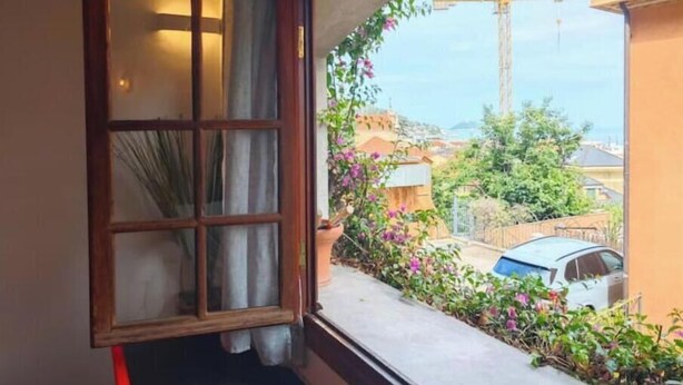 Una habitación con ventana que da a un jardín y una obra.