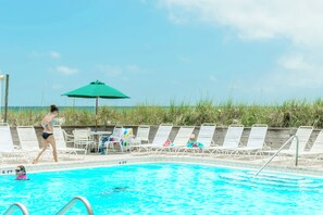 Ein Schwimmbecken mit Liegestühlen und Sonnenschirm.