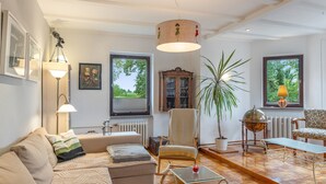 Una sala de estar con sofá, sillón, mesa y un globo terráqueo sobre un atril.