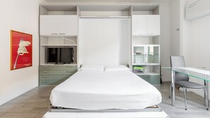 Ein modernes Schlafzimmer mit Bett, Schreibtisch und integrierten Stauraumlösungen.