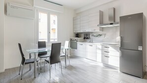 Eine moderne Küche mit Essbereich, Edelstahlgeräten und Blick ins Freie.