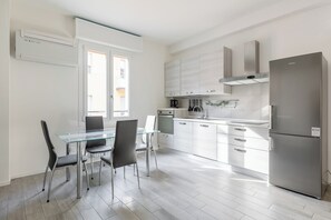 Eine moderne Küche mit Essbereich, Edelstahlgeräten und Blick ins Freie.