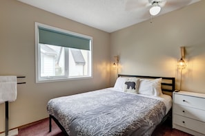 A bedroom with a bed, a nightstand, a lamp, and a window. - CRC140: Summer Availability, Perfect for families (Canmore)