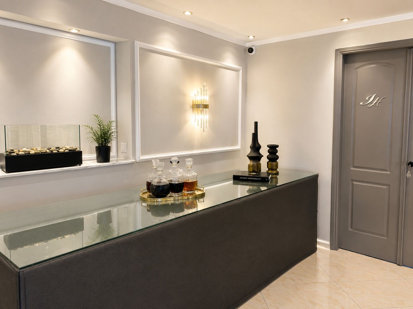 A reception area with a glass counter, a potted plant, and a wall-mounted light fixture.