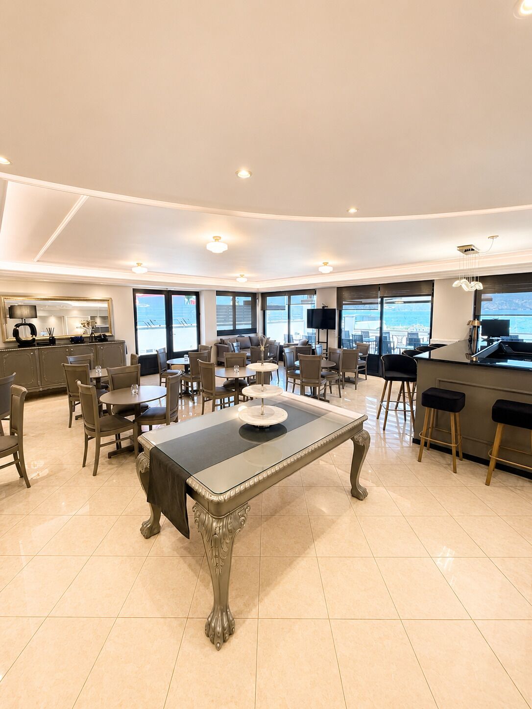Uma sala de jantar espaçosa com uma mesa central, várias cadeiras e um espaço de bar com banquetas.