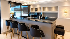 Una cocina moderna con barra, que incluye una isla central, taburetes de bar y electrodomésticos integrados.