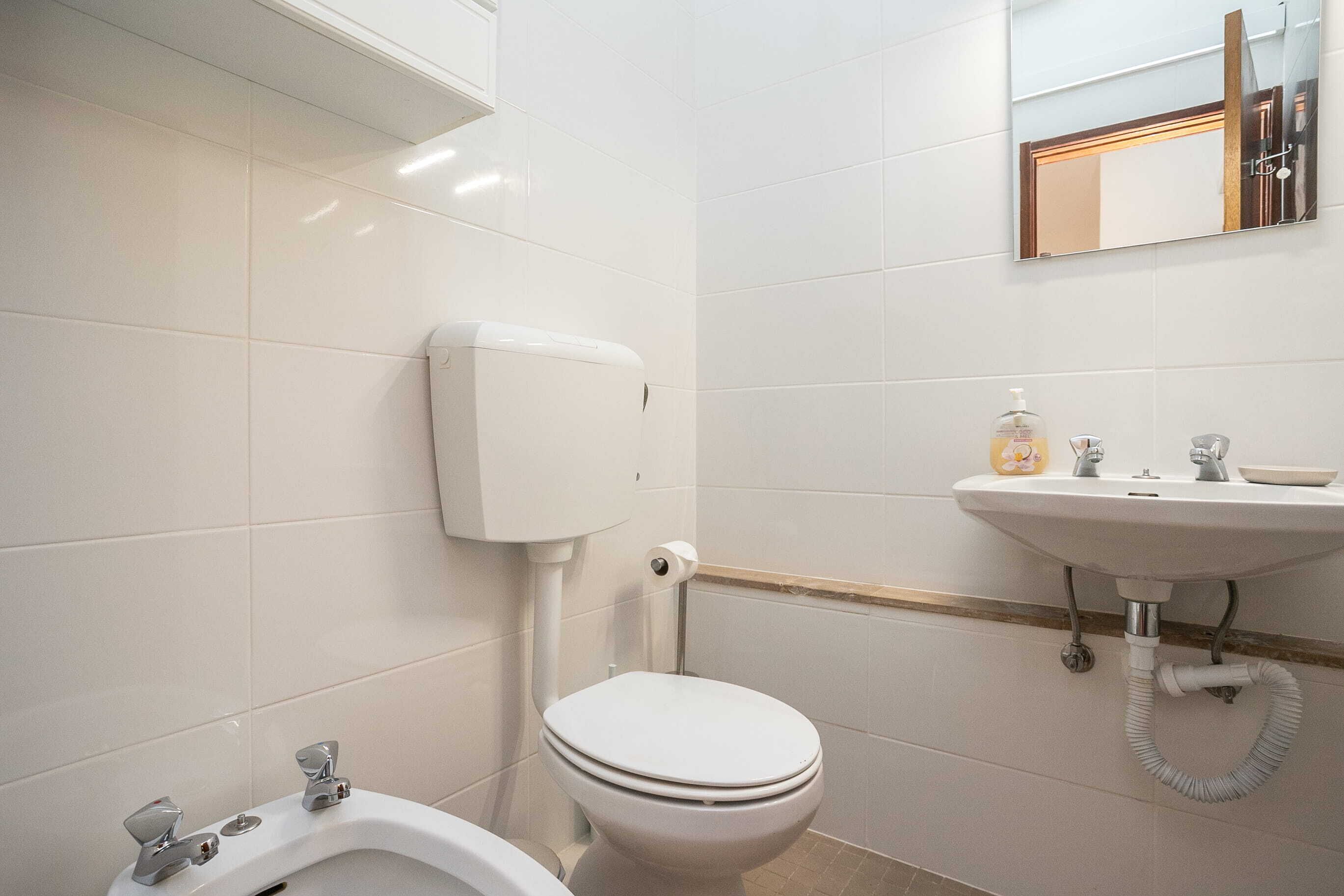 A bathroom with a toilet, bidet, and sink.