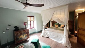 A bedroom with a canopy bed, a floor lamp, a dresser, and a window with curtains. - Piece of Pai (Sainte-Hermine)