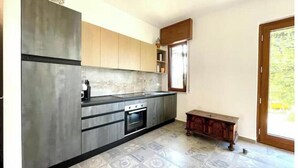 Een moderne keuken met roestvrijstalen apparatuur, houten kastjes en vloertegels met een patroon.
