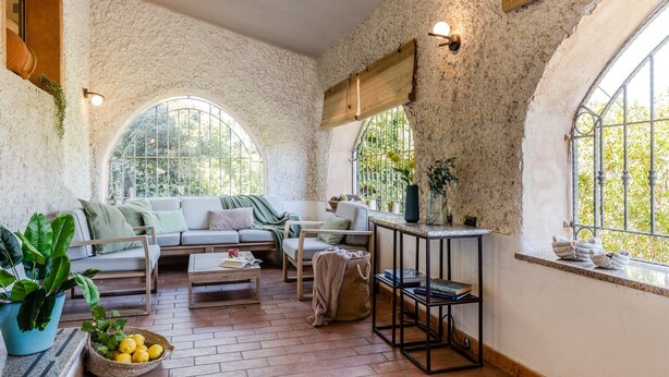 Un salon chaleureux avec un canapé, une table basse et une petite table sur laquelle est posée une plante.