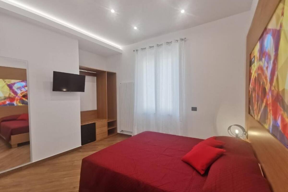 Une chambre d’hôtel moderne avec un grand lit, une télévision, une armoire en bois et une fenêtre avec des rideaux.