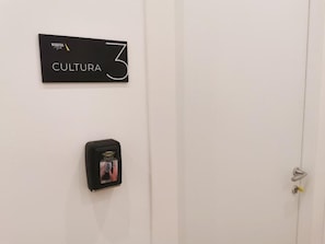 Eine Tür mit einem Schild, auf dem 'MAQUEDA CULTURA 3' steht, und einer Sicherheitsvorrichtung darunter.