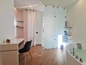 A modern room with a desk, chair, glass partition, and a bathtub. - Maqueda Mood (Palermo)