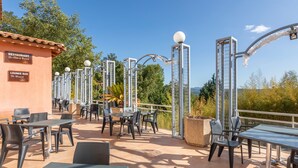 An outdoor patio area with tables and chairs, a lounge bar, and exercise equipment.