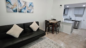 A living room with a black sofa, a patterned rug, and abstract wall art. - 4min to World Cup Stadium/Dallas Stadium - 0.9 mile from AT&T Stadium Arlington (Arlington)