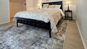 A bedroom with a bed, two bedside lamps, a ceiling fan, and a door leading to another room. - 4min to World Cup Stadium/Dallas Stadium - 0.9 mile from AT&T Stadium Arlington (Arlington)