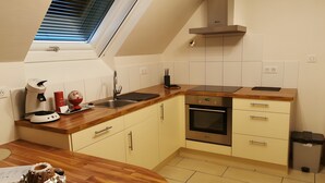 Eine Küche mit Dachfenster, einem eingebauten Backofen und einer Holzarbeitsplatte.
