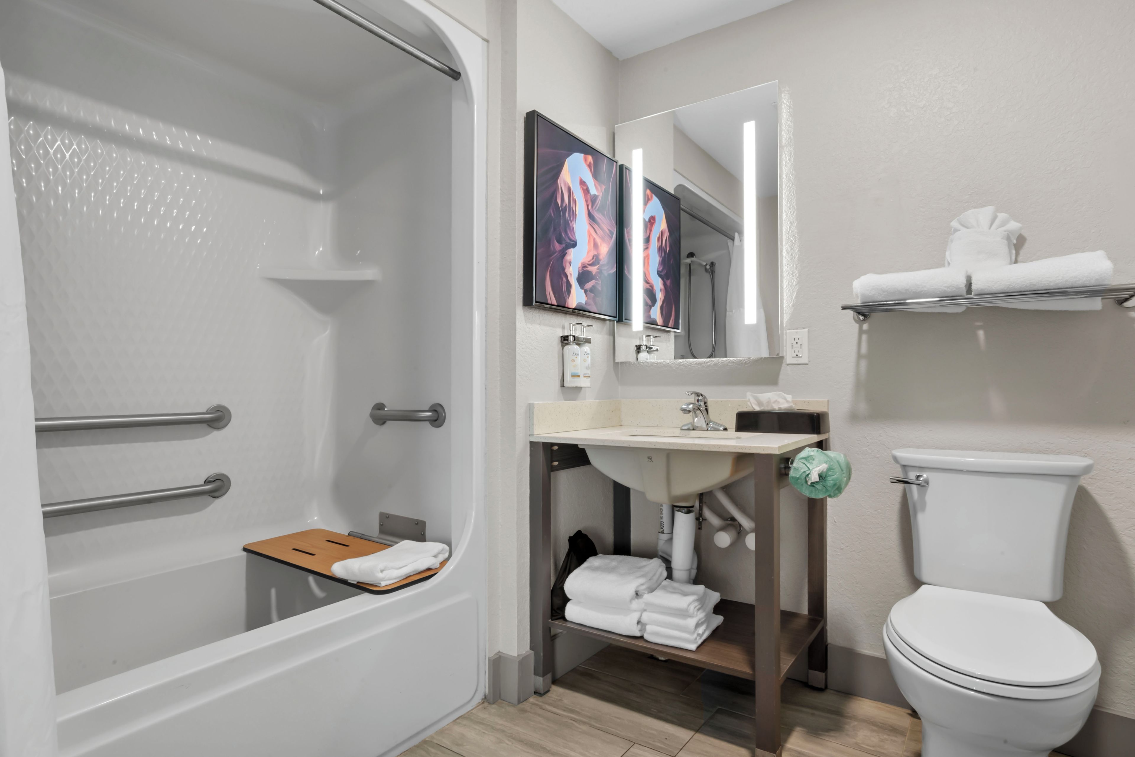 A modern bathroom with a shower, toilet, sink, and a towel rack.