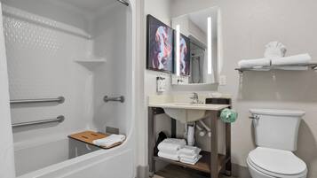A modern bathroom with a shower, toilet, sink, and a towel rack.