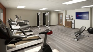 A fitness center with treadmills, a weight machine, and a wall-mounted sign for Candlewood Suites. - Candlewood Suites Panama City Beach Southeast By Ihg (Panama City Beach)