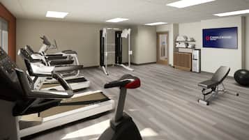 A fitness center with treadmills, a weight machine, and a wall-mounted sign for Candlewood Suites.