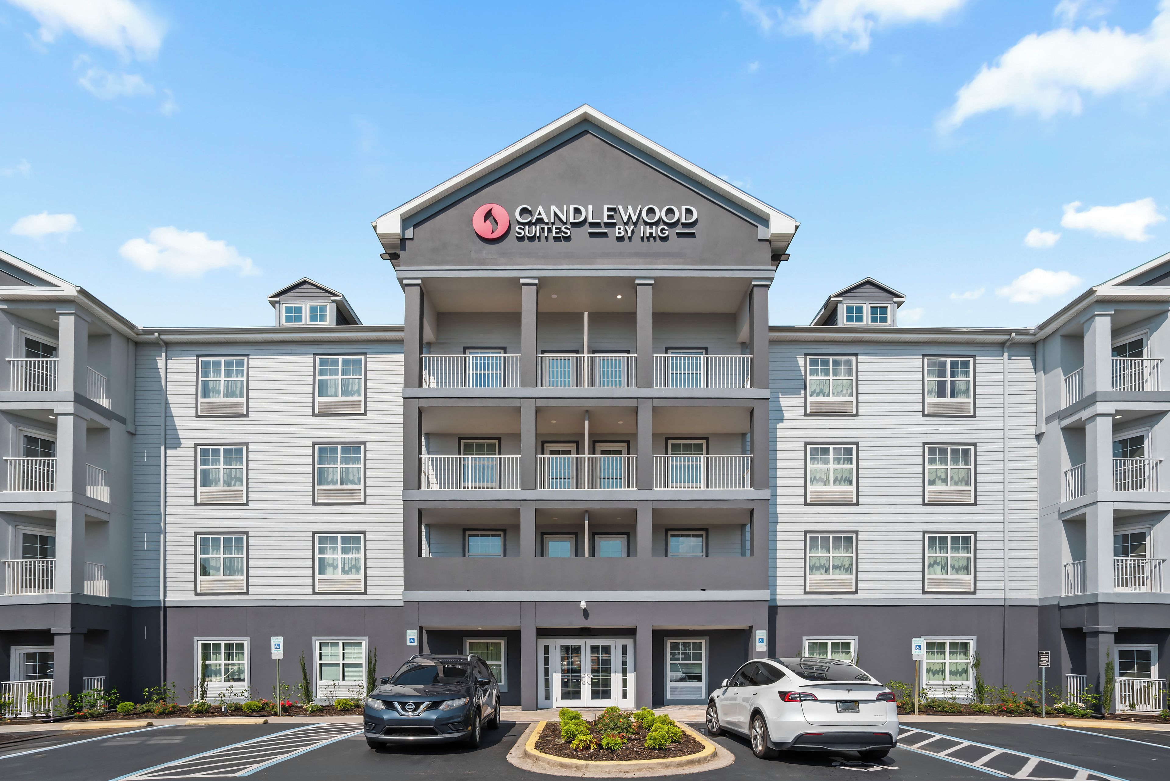 A multi-story hotel with a prominent sign for Candlewood Suites by IHG.