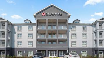 Um hotel com vários andares e uma placa grande com a inscrição Candlewood Suites by IHG.