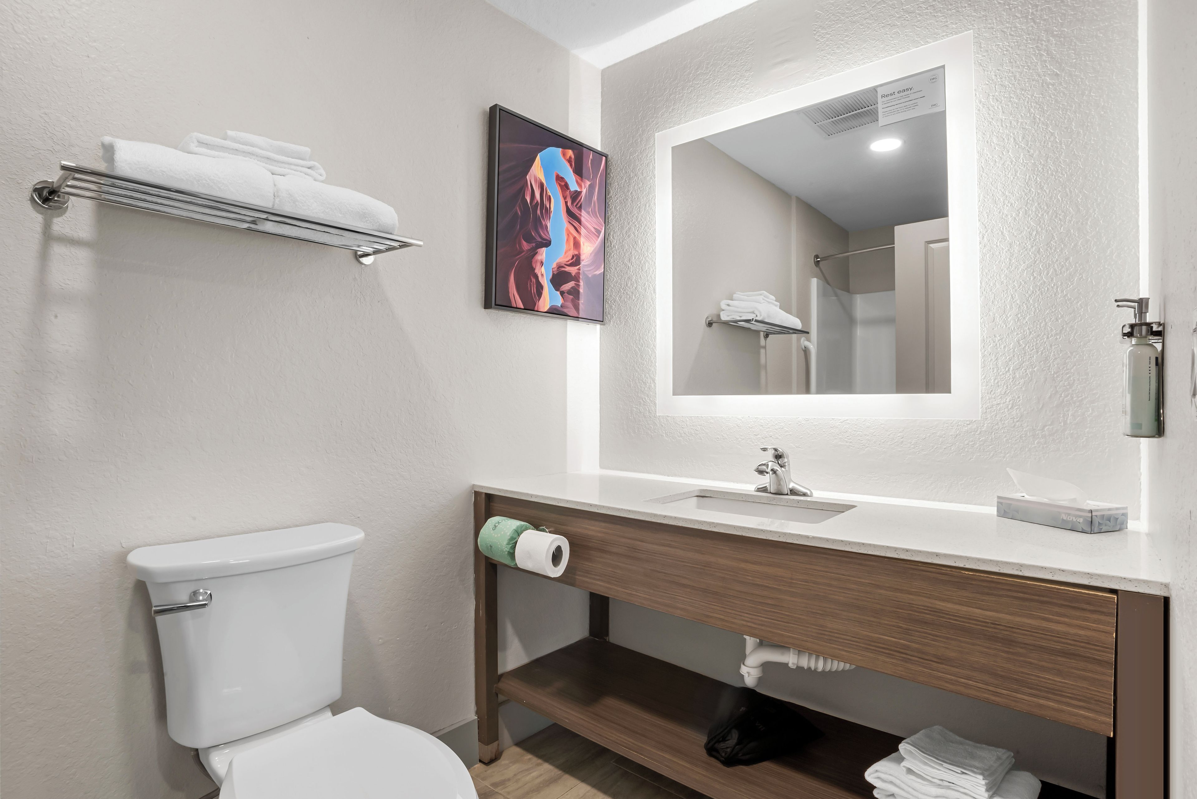 Un baño moderno con inodoro, lavabo y perchero para toallas.