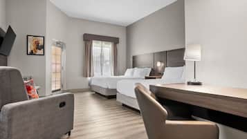 A hotel room with a bed, a desk, a chair, a lamp, and a painting on the wall.
