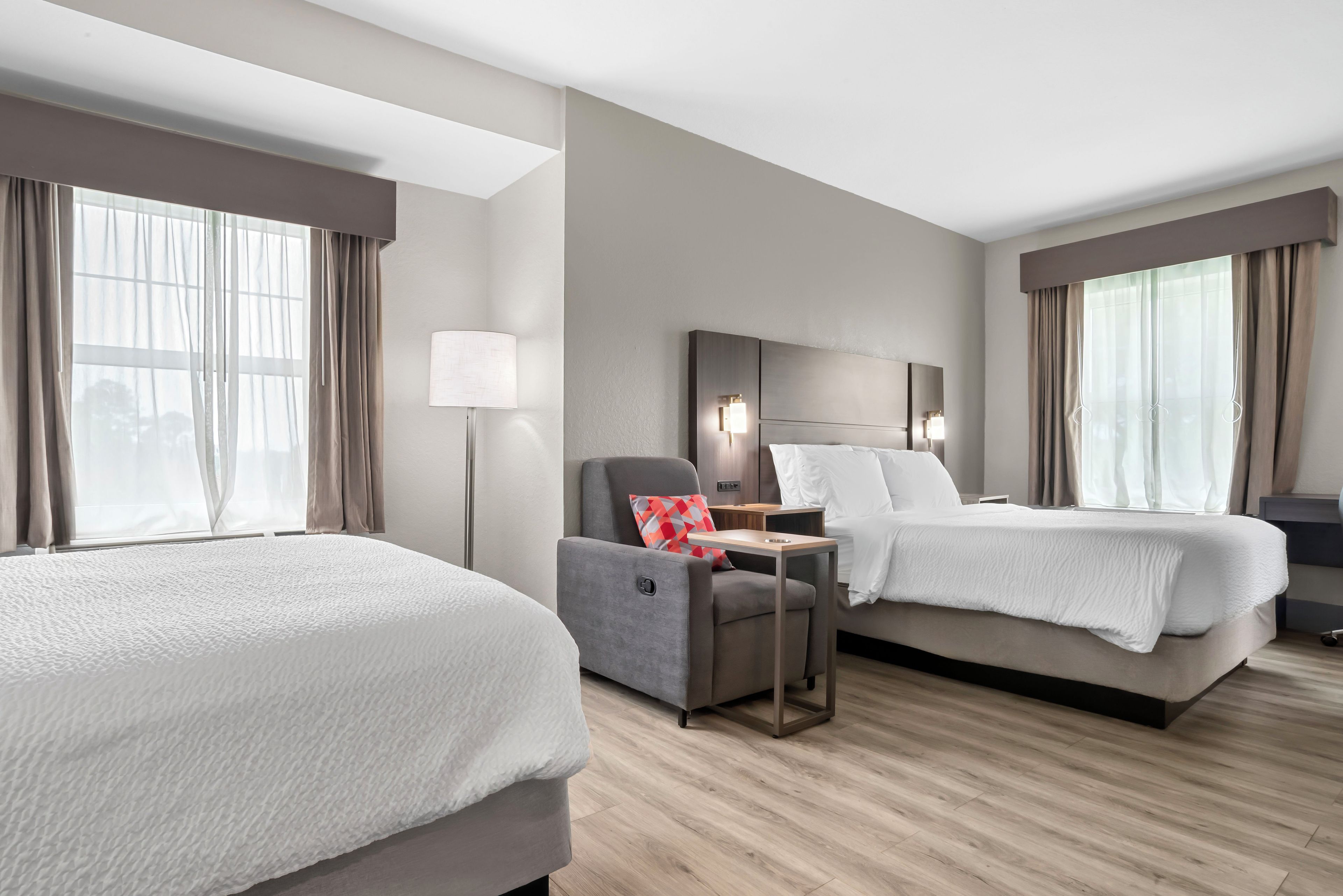 Ein Hotelzimmer mit zwei Betten, einem Schreibtisch und einem Stuhl.