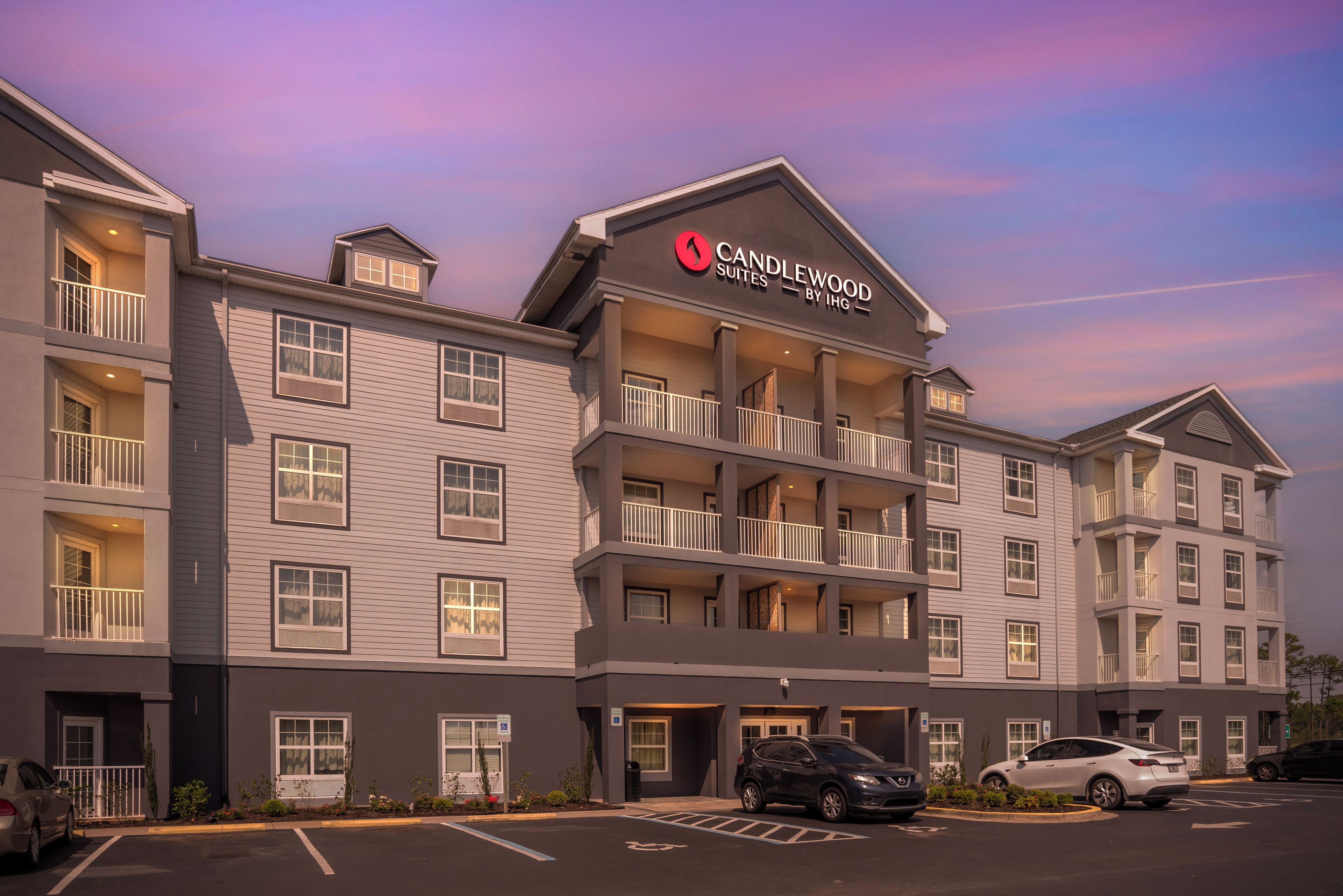 Um hotel com vários andares e uma placa bem visível para Candlewood Suites by IHG.