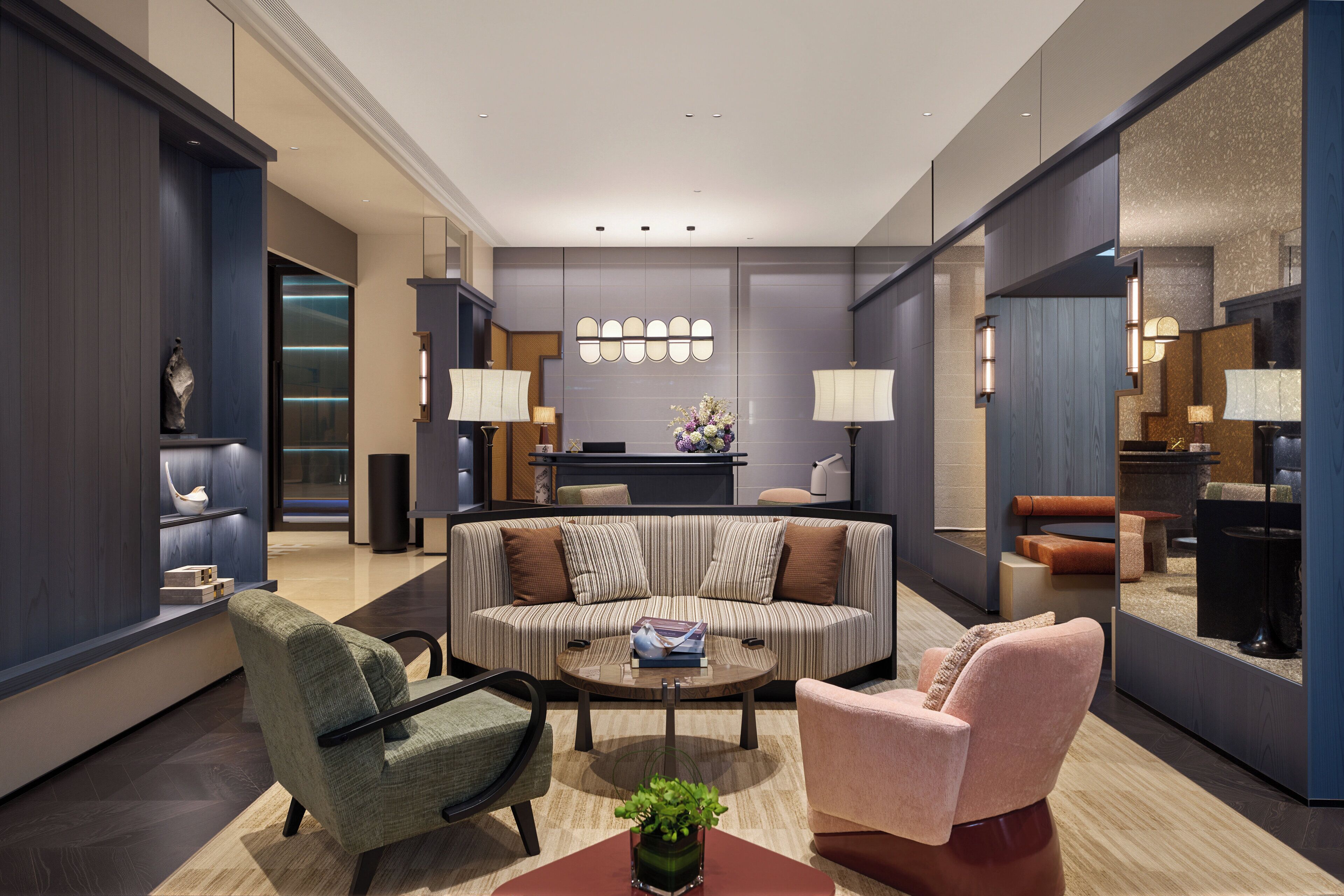 A modern living room with a sofa, armchairs, a coffee table, and a fireplace.