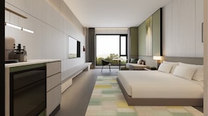 A modern hotel room with a large bed, a desk, a chair, and a view of the outdoors.