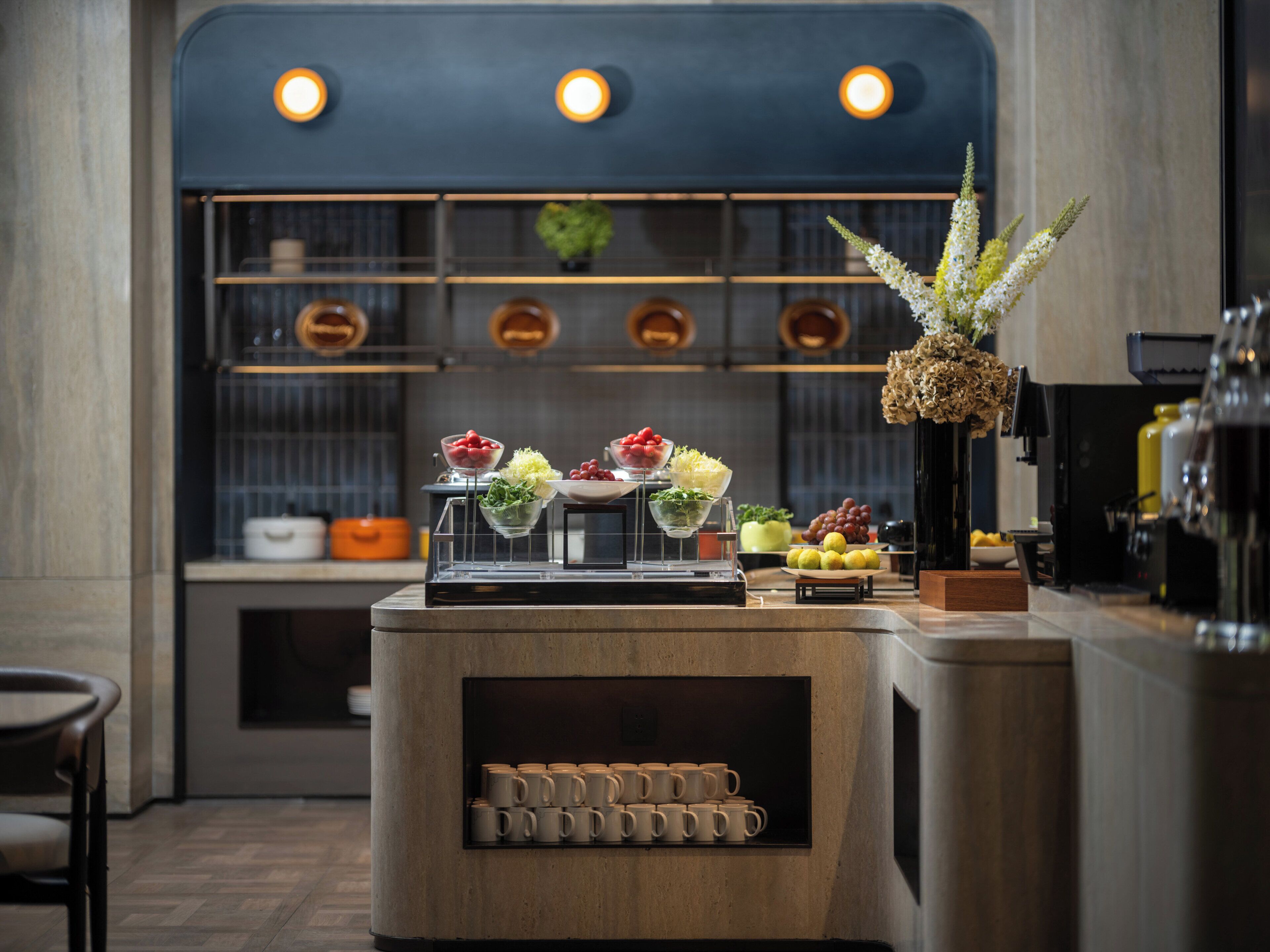 A bar area with a counter displaying various food items and a selection of mugs.