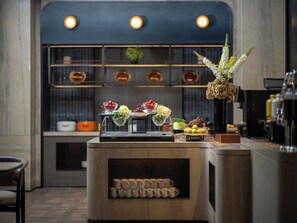 Un espace bar avec un comptoir où sont exposés divers produits alimentaires et une sélection de tasses.