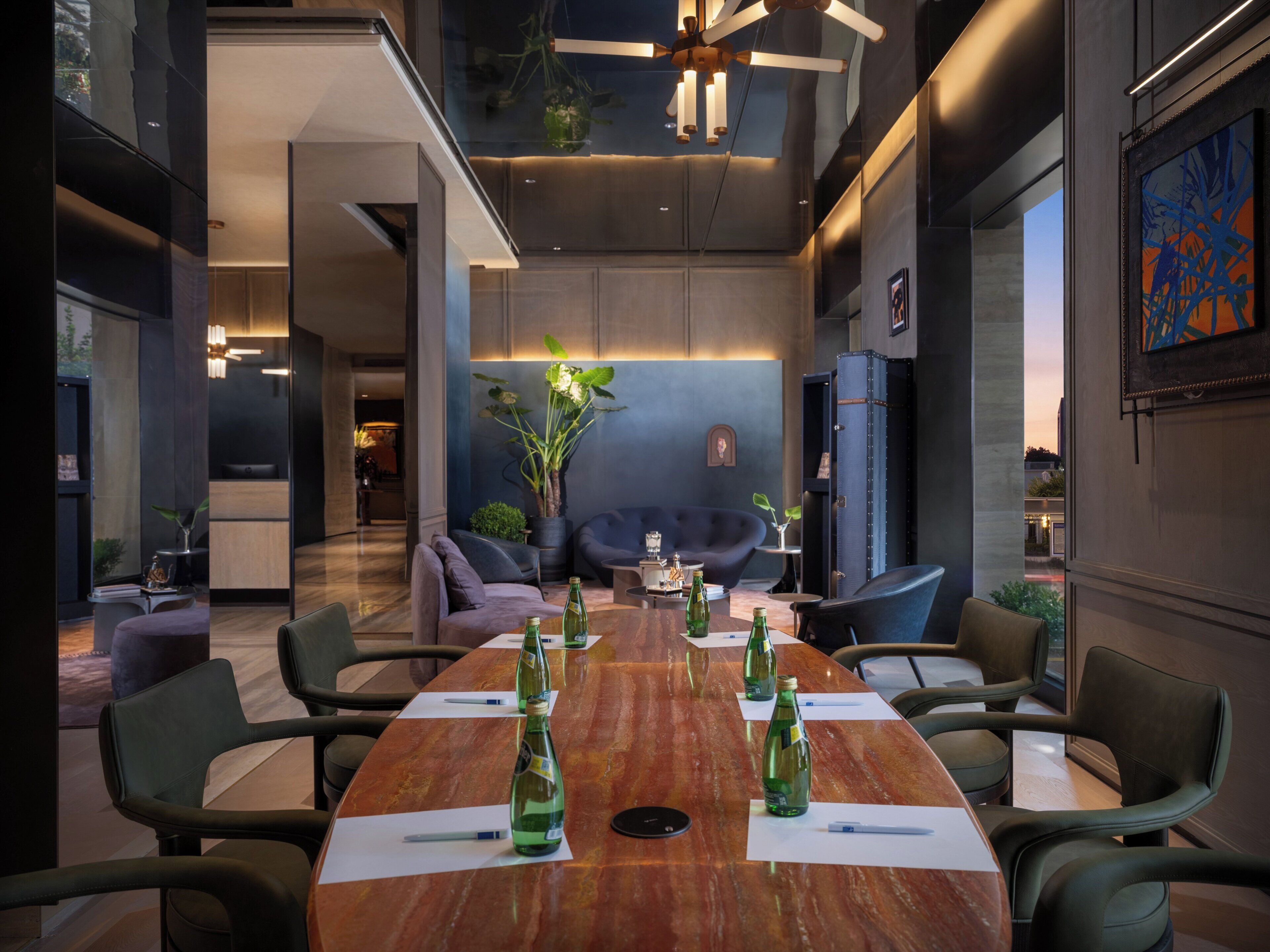 Een moderne vergaderruimte met een houten tafel, stoelen en groene flessen.