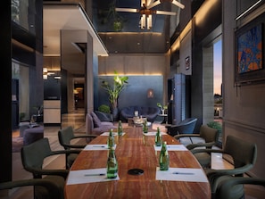 A modern conference room with a wooden table, chairs, and green bottles.