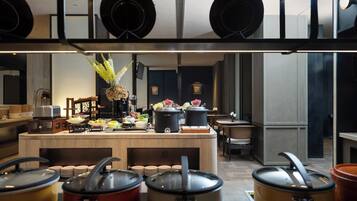 Una cocina moderna con una isla central, ollas y diversos alimentos.
