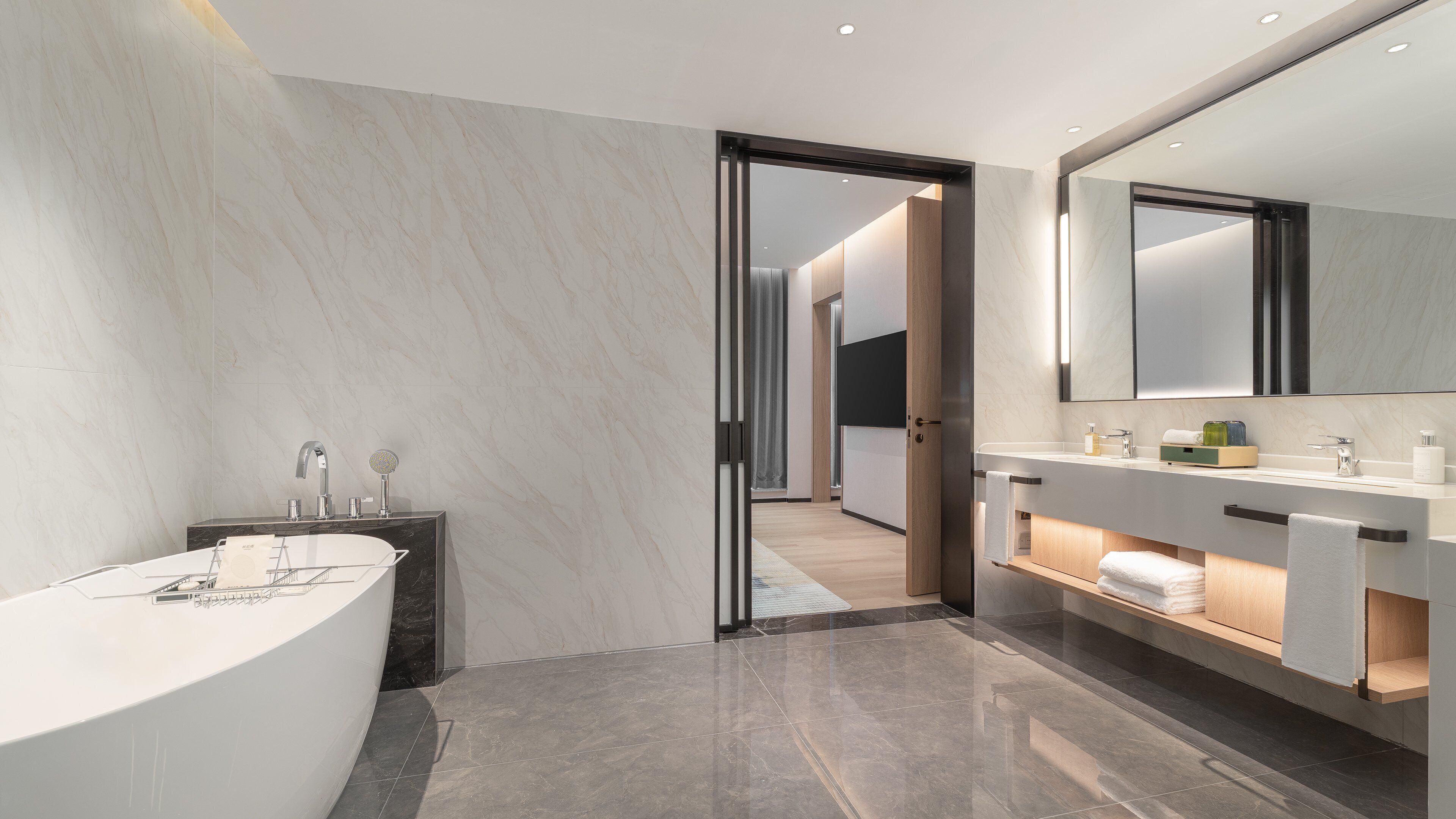 A modern bathroom with a freestanding bathtub, a vanity with a mirror, and a shower area.