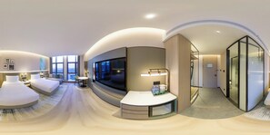Une chambre d’hôtel moderne au design épuré, dotée d’un grand téléviseur, d’un coin salon et offrant une vue sur la ville.